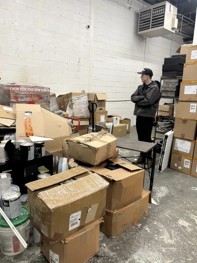 Team member of 24-7JUNK.COM's Chicago Commerical Waste Removal Team Evaluating Waste for Removal in a stockroom in Chicago. 60614